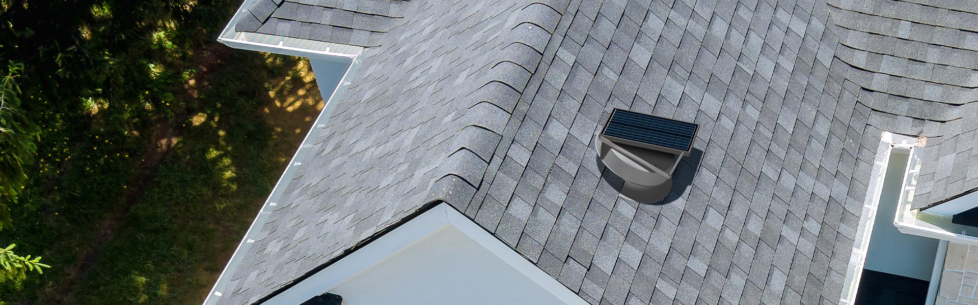 Aerial view of Natural Light adjustable solar attic fan on home with asphalt roof